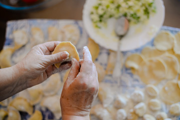Closeup view of making traditional dumplings on kitchen table background