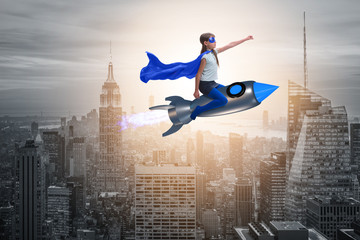 Fototapeta na wymiar Little girl flying rocket in superhero concept