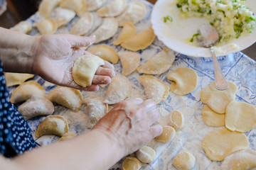 Closeup view of making traditional dumplings on kitchen table background