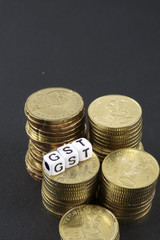 Stack of coins and GST word. Business and taxation concept.