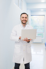 Portrait Of Doctor Holding Laptop, Indoors