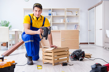 Repairman carpenter cutting sawing a wooden board with an electr