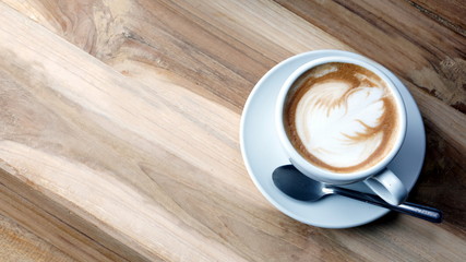 Latte art and cappuccino on the table with roasting coffee beans. Beverage and breakfast or food and drink menu with hot coffee at the cafe shop.
