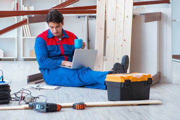 Young carpenter with a laptop computer