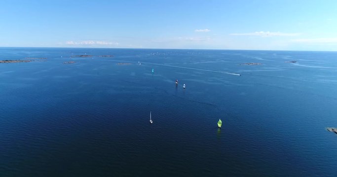Yachts on baltic sea, Cinema 4k aerial view above the baltic sea and towards a group of colorful sailboats, out on the turquoise sea, on hango regatta day, in the finnish archipelago of Hanko, Finland