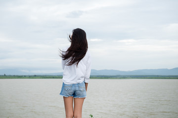 portrait of beautiful young woman standing on the mountain and relaxing