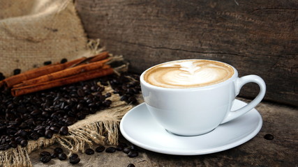 Latte art and cappuccino on the table with roasting coffee beans. Beverage and breakfast or food and drink menu with hot coffee at the cafe shop.
