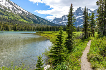 Mountain Lake Trail - A spring view of a hiking trail along Lake Josephine at the base of Mount Gould in Many Glacier region of Glacier National Park, Montana, USA.