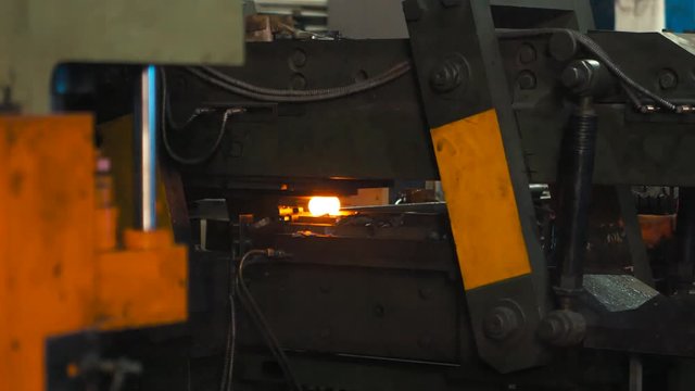 Forging steel machine inside industrial plant.
