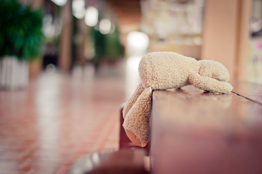 Brown teddy bear dropped on wooden couch.selective focus.