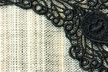 Obraz premium Detail of black lace on rough simple fabric