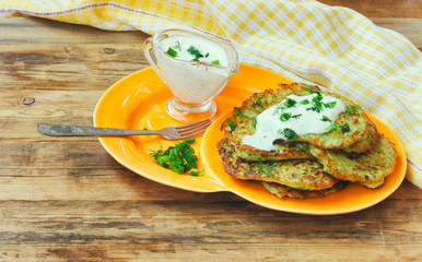 Homemade fried fritters from courgettes on orange plate closeup