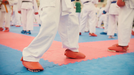Karate training - group of karateka teenagers in red shoes and white kimono © KONSTANTIN SHISHKIN