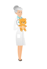 Senior caucasian pediatrician holding teddy bear.