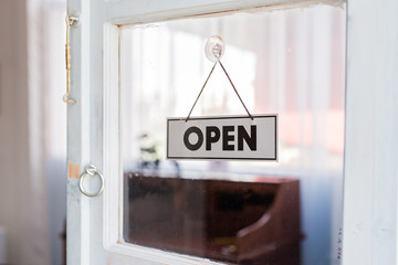 Open sign hanging in a shop window