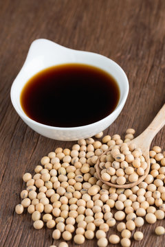 Soy sauce with Soy bean on wood table.