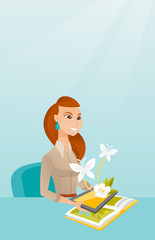 Young woman holding tablet computer above the book