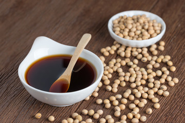 Soy sauce with Soy bean on wood table.