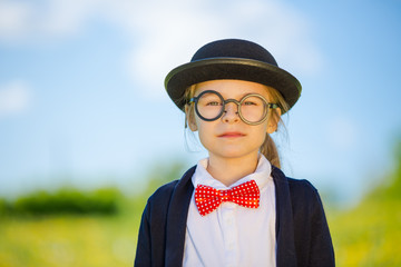 Funny little girl in bow tie and bowler hat. Retro stile.