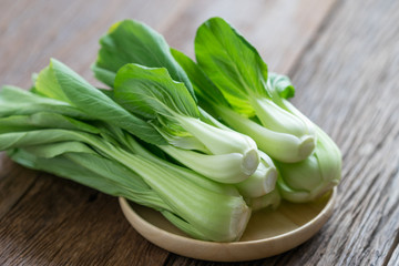 Bok choy (chinese cabbage) on wooden table. - obrazy, fototapety, plakaty