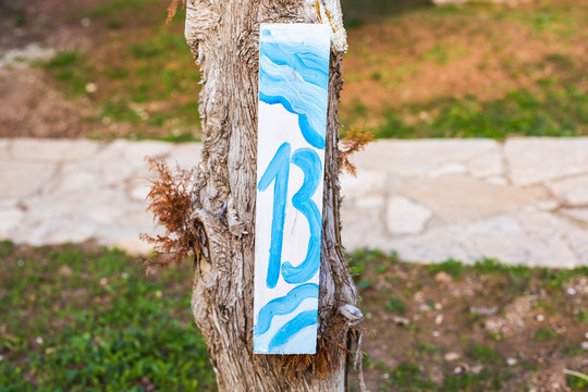 Number thirteen 13 painted on wooden signboard