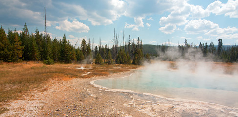 Sunset Lake under cumulus clouds in Black Sand Basin in Yellowstone National Park in Wyoming United...