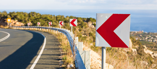 Left Turn Sign: Road signs warn of a sharp turn on a narrow road