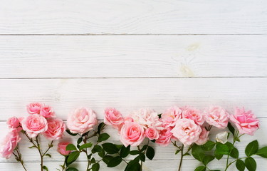 Fototapeta na wymiar Bouquet of beautiful pink roses on white wooden background.Top view.Copy space