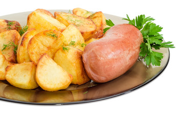 Fried potatoes with wieners on glass dish closeup