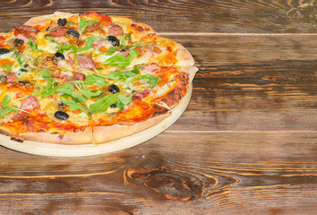Cooked pizza on a old wooden table