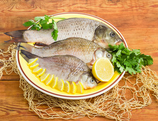 Carp and crucians prepared for cooking on dish