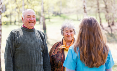 Elderly couple and young caregiver