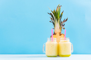Two mason jars with smoothie on vibrant background