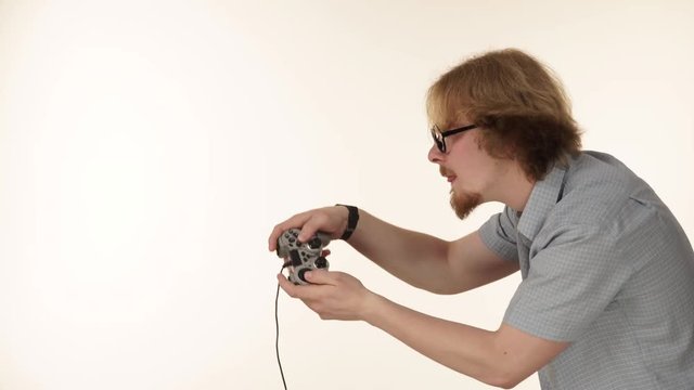 Videogame addicted guy playing with controller console. Young male gamer with pad joystick playing games, side view 4K ProRes HQ codec