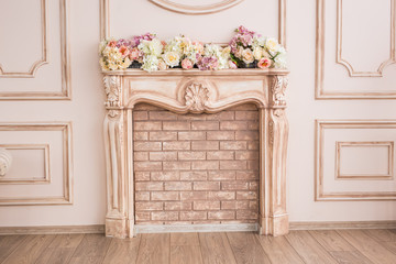 Beautiful beige fireplace with decorative flowers close-up