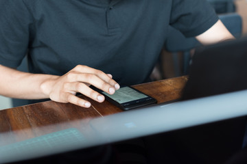 A freelancer is working on a new project on laptop computer and smart phone in soft focus at coffee shop in weekend.