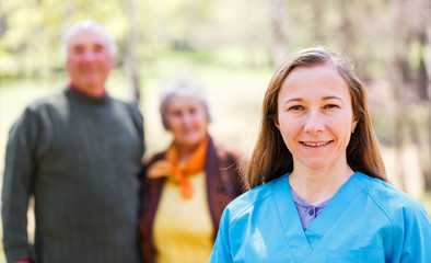 Elderly couple and young caregiver