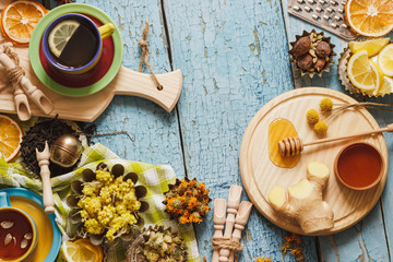 Cups with herbal tea and pieces of lemon, dried herbs and different decorations