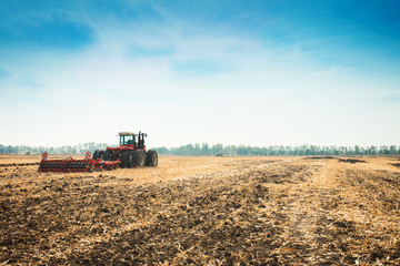 Modern tractor in the field with complex for the plowing.