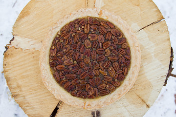 Pecan pie served outdoors with a log as a table