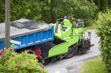 Asphalt roadwork. Machine and truck on the road parked.