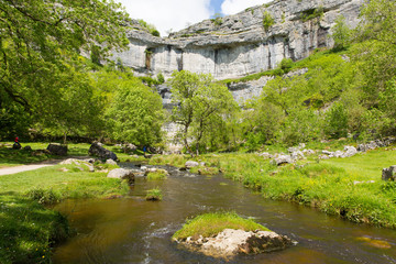 Fototapeta na wymiar Malham Cove with the stream at the bottom of the rocks Yorkshire Dales National Park UK
