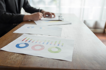 Stock graph on desk Businessman has a young man behind a desk