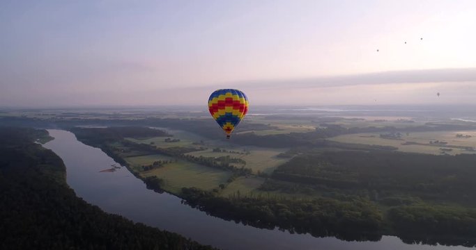 air baloon over green lands at early mornig