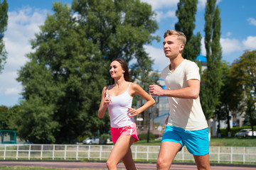 Couple running on arena track.