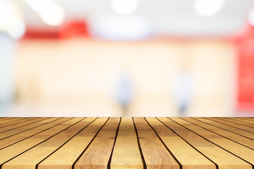 Perspective wooden table on top over blur coffee shop background, can be used mock up for montage products display or design layout.