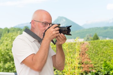  mature man with dslr camera, outdoors