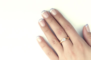 Female hand with a ring on a white background