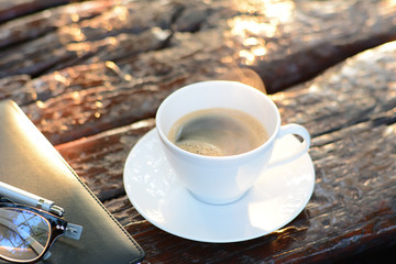 Fototapeta na wymiar Black coffee in the cup on old dark brown wood background
