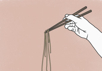 Cropped image of hand holding noodles with chopsticks against pink background